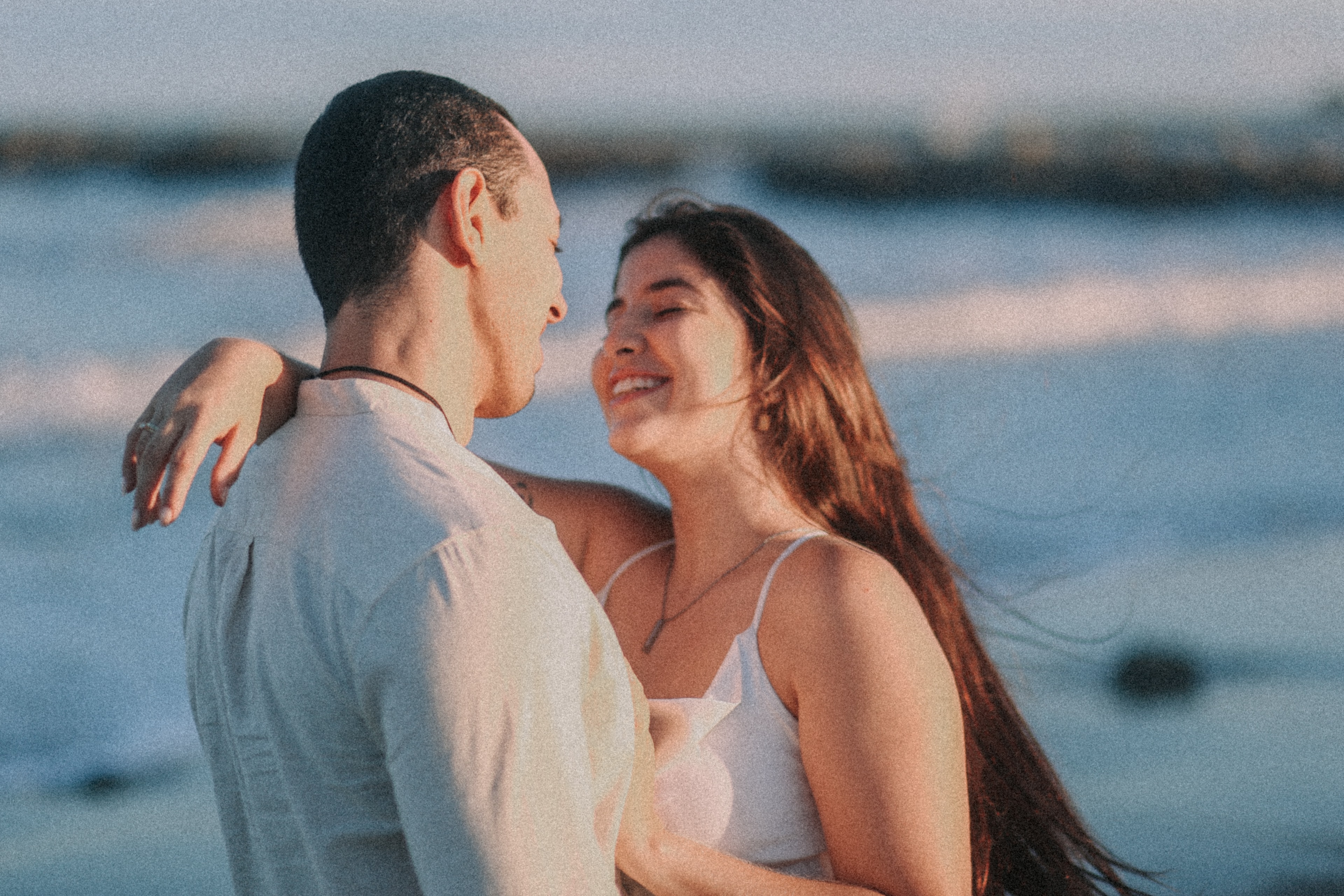Thiago levantando Morgana na praia ao entardecer