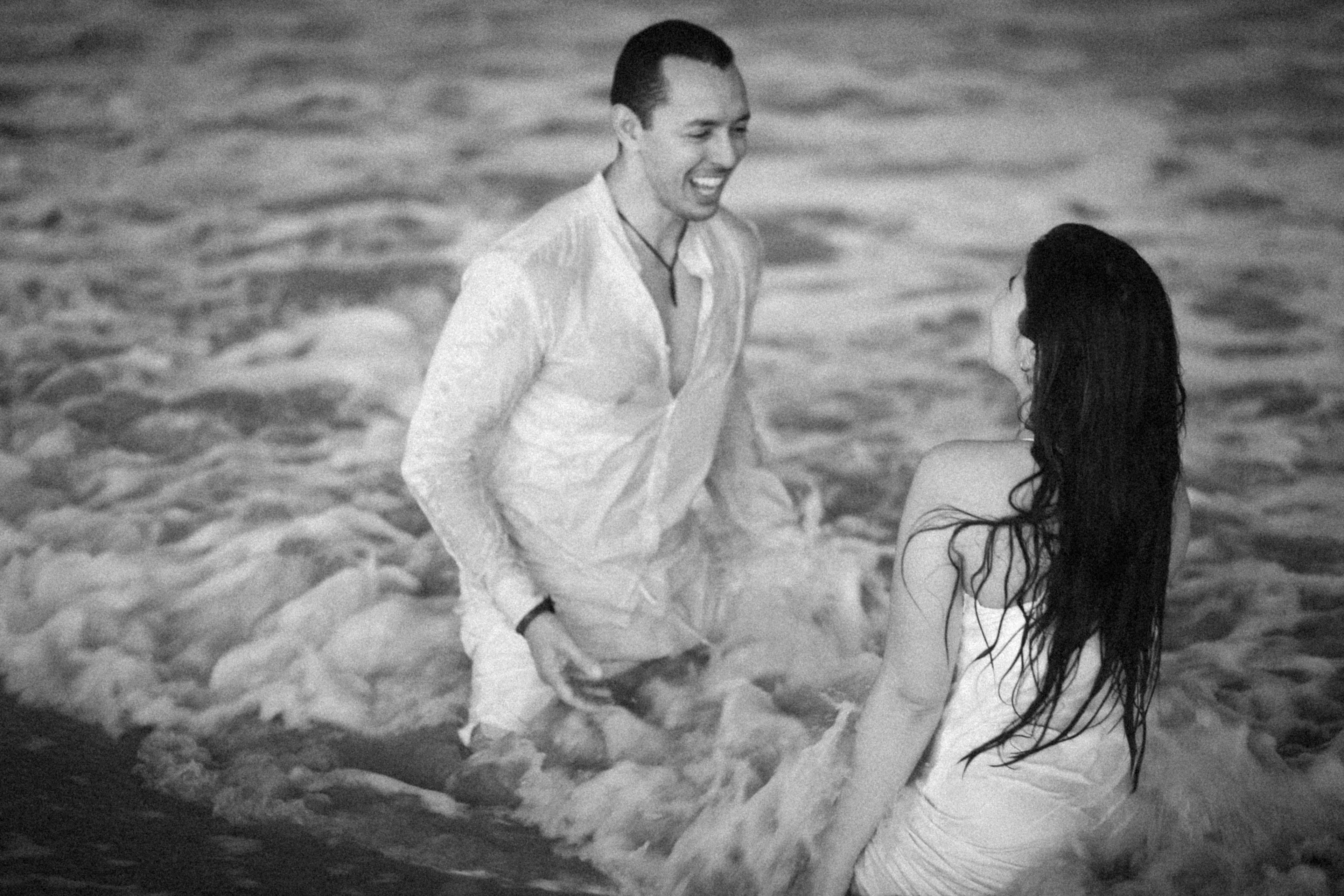 Casal brincando nas ondas do mar