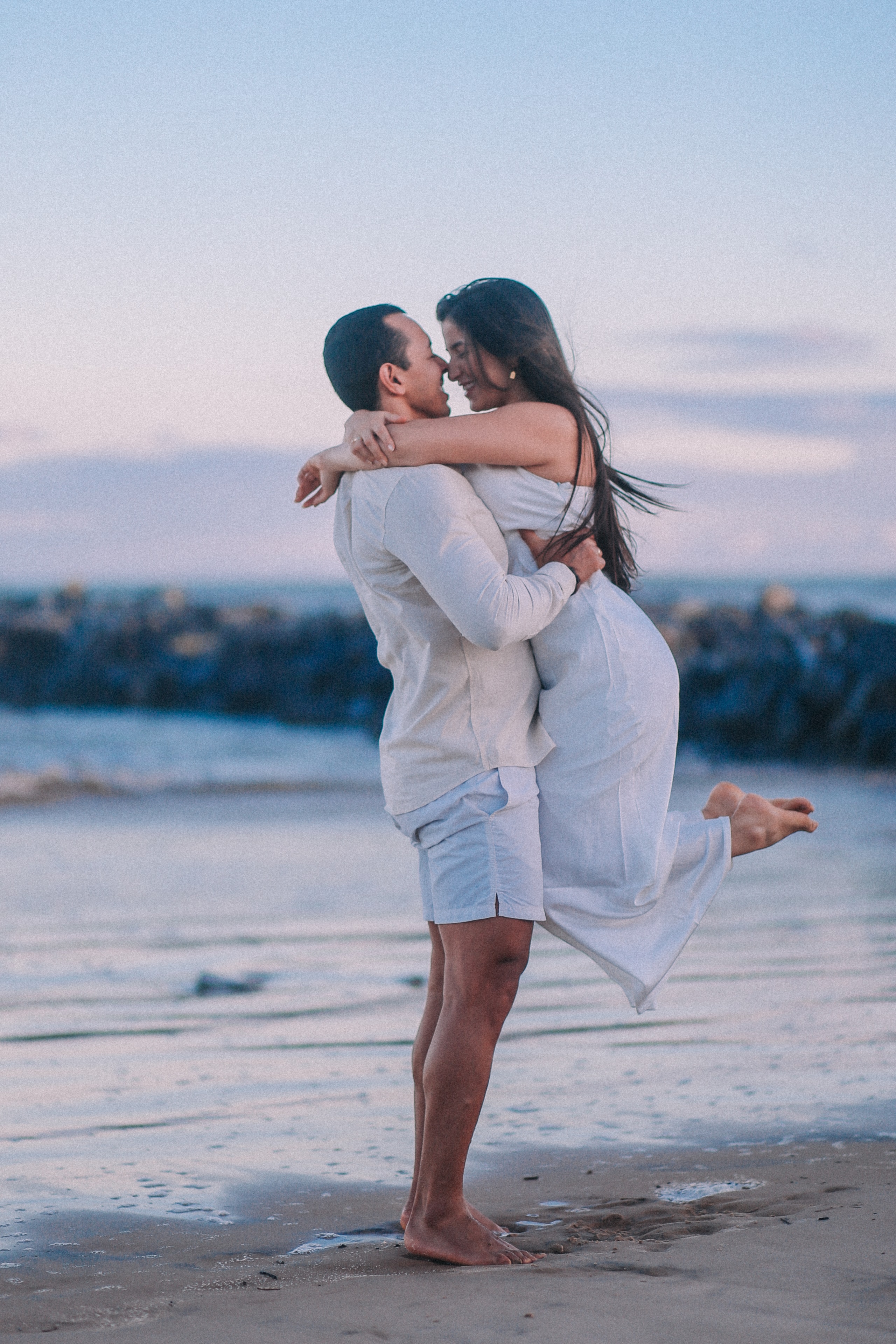 Morgana e Thiago sorrindo juntos na praia